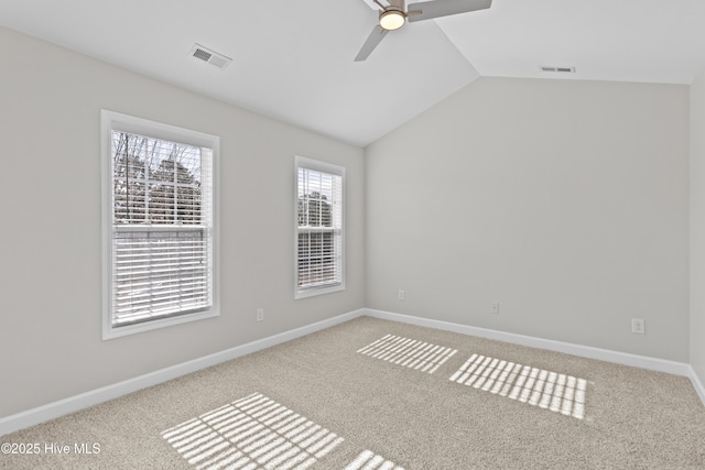 carpeted spare room featuring baseboards, visible vents, vaulted ceiling, and a ceiling fan