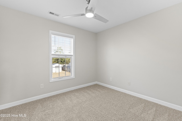 carpeted spare room with ceiling fan, visible vents, and baseboards