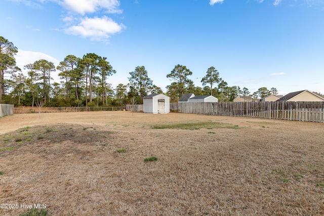 view of yard with a storage shed, an outbuilding, and a fenced backyard