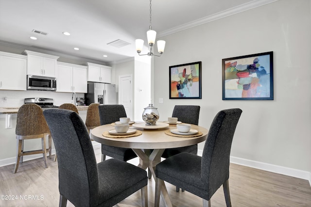 dining space with ornamental molding, an inviting chandelier, and light hardwood / wood-style flooring