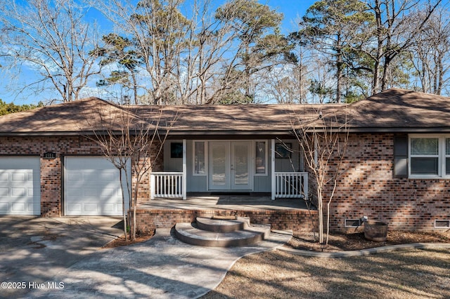 ranch-style home with a porch and a garage