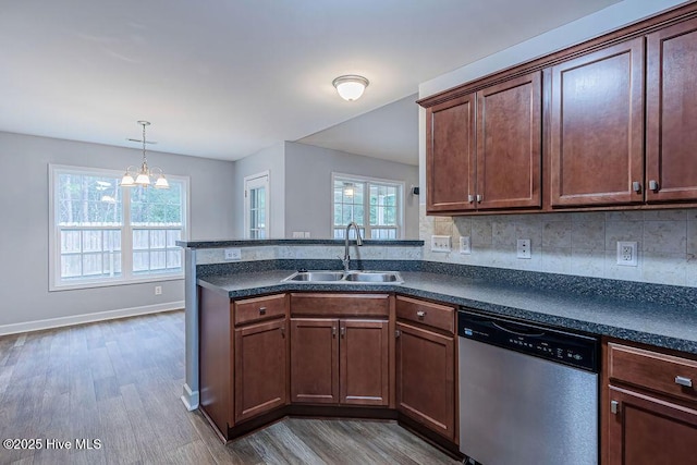 kitchen featuring sink, light hardwood / wood-style flooring, stainless steel dishwasher, kitchen peninsula, and backsplash