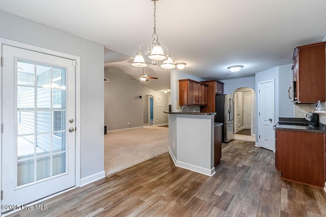 kitchen featuring ceiling fan, high end fridge, stove, dark hardwood / wood-style flooring, and decorative light fixtures