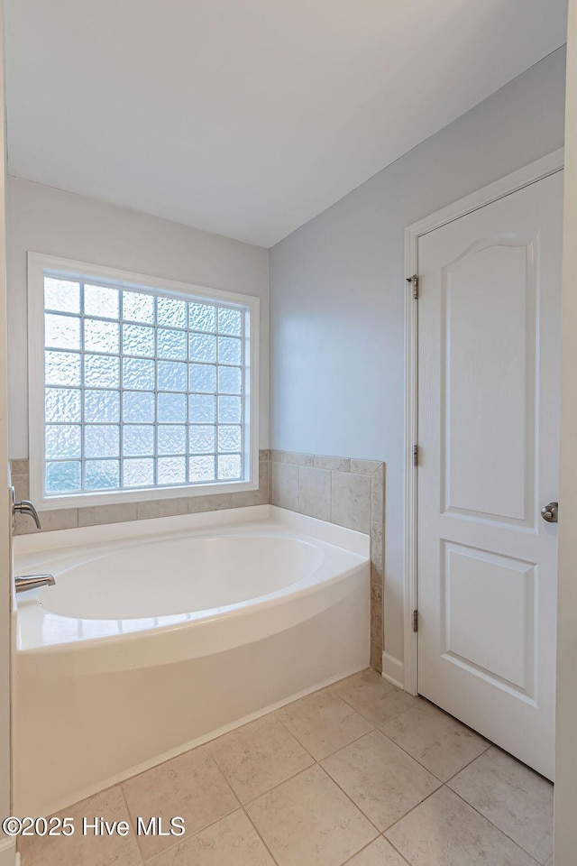 bathroom featuring tile patterned flooring and a tub to relax in