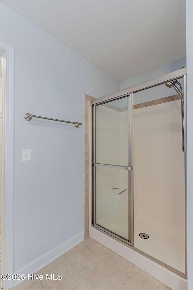 bathroom featuring a shower with shower door and tile patterned flooring