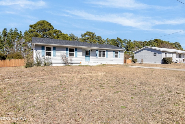 single story home with a front lawn and fence