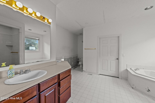 bathroom featuring baseboards, a garden tub, vanity, and toilet