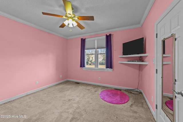 exercise room featuring crown molding, baseboards, carpet, a textured ceiling, and a ceiling fan