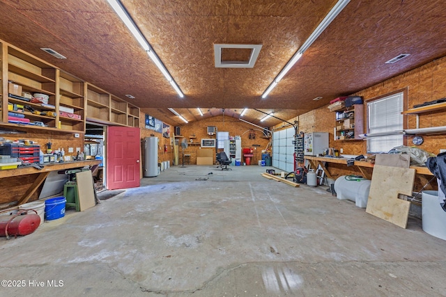 garage featuring gas water heater, visible vents, and a workshop area