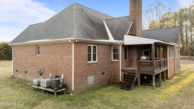 rear view of house featuring a shingled roof, a yard, a chimney, and crawl space