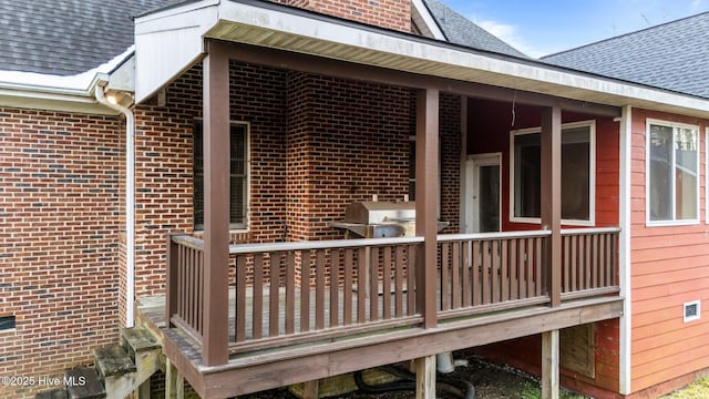 view of property exterior featuring brick siding and roof with shingles