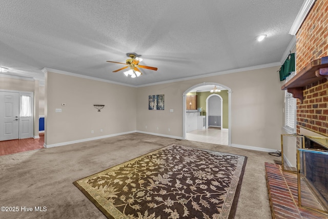 living area with light carpet, ornamental molding, a textured ceiling, arched walkways, and ceiling fan