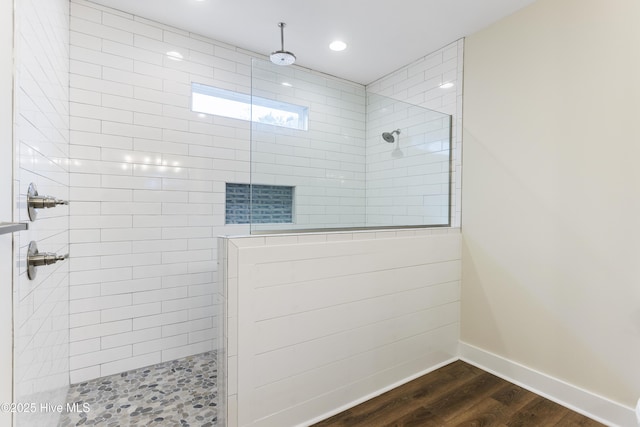 bathroom with hardwood / wood-style flooring and tiled shower