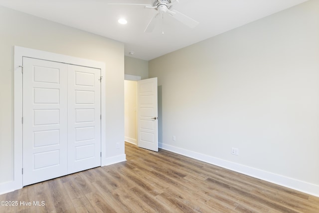 unfurnished bedroom featuring ceiling fan, a closet, and light hardwood / wood-style flooring