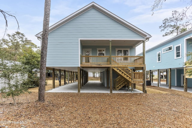 back of house with a carport, covered porch, and central air condition unit