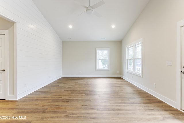 spare room featuring ceiling fan, lofted ceiling, and light hardwood / wood-style flooring