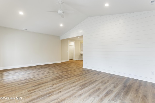 spare room featuring ceiling fan, lofted ceiling, and light hardwood / wood-style flooring