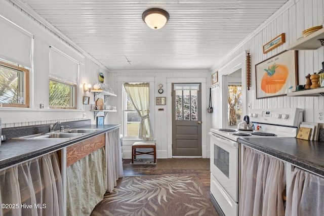 kitchen featuring a sink, dark countertops, open shelves, and white range with electric stovetop