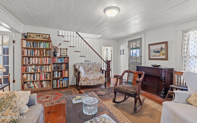 living area featuring stairs, crown molding, and wood finished floors