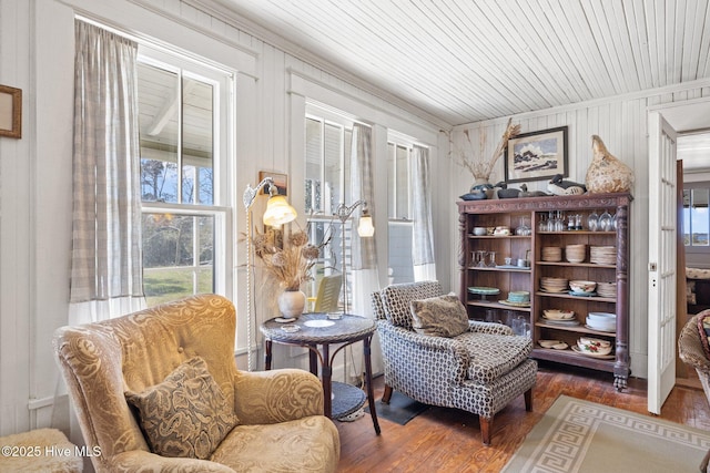 sitting room with wooden ceiling, wood finished floors, and ornamental molding