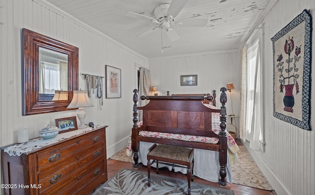 sitting room featuring ceiling fan, baseboards, wood finished floors, and crown molding