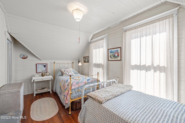 bedroom featuring multiple windows, wood finished floors, and vaulted ceiling