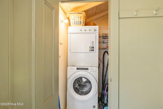 laundry area featuring wood ceiling, laundry area, and stacked washing maching and dryer