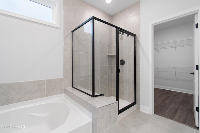 bathroom with tile patterned flooring and separate shower and tub