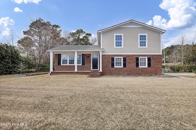 view of front of home featuring a front yard and brick siding