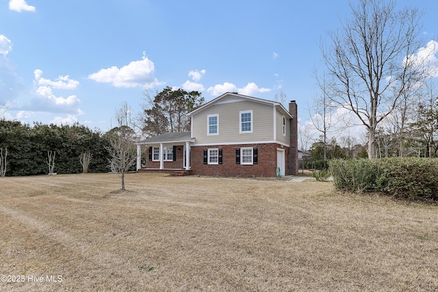 traditional home featuring a chimney, a front lawn, and brick siding