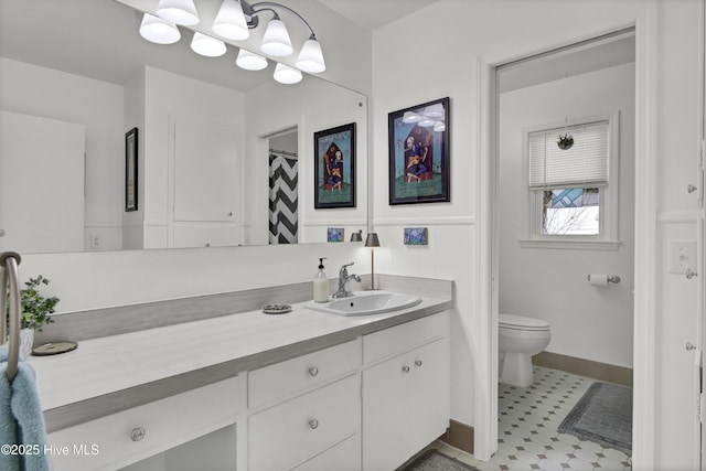 full bathroom with toilet, baseboards, and vanity