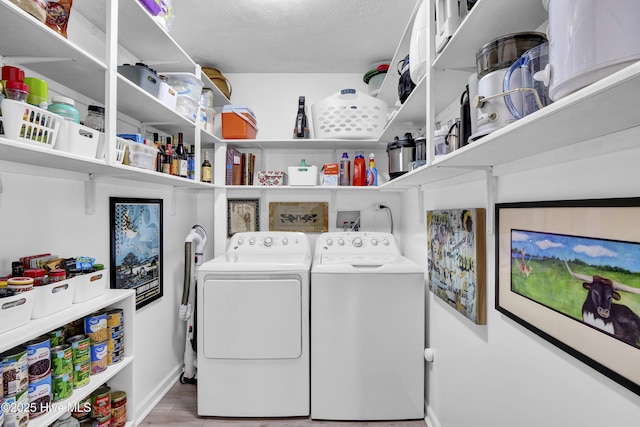 washroom with baseboards, laundry area, wood finished floors, and washer and dryer