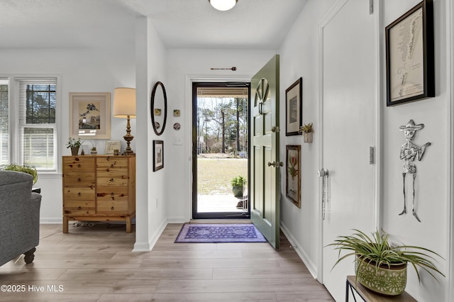 foyer featuring light wood-style flooring and baseboards