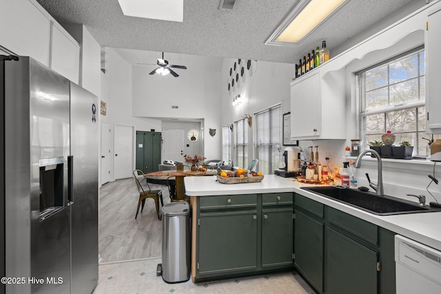 kitchen featuring sink, stainless steel fridge, white cabinets, and dishwasher