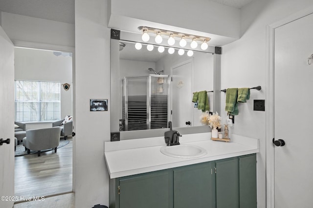 bathroom featuring vanity, hardwood / wood-style flooring, and a shower with shower door