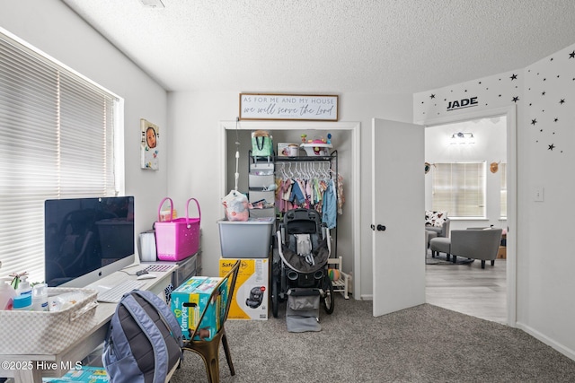 carpeted home office featuring a textured ceiling