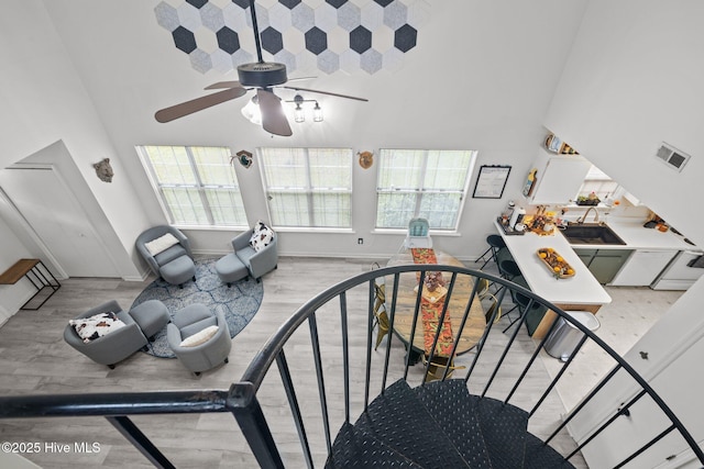 stairs with hardwood / wood-style floors and a towering ceiling