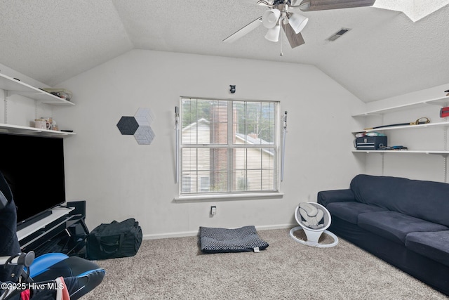 carpeted living room featuring ceiling fan, lofted ceiling, and a textured ceiling