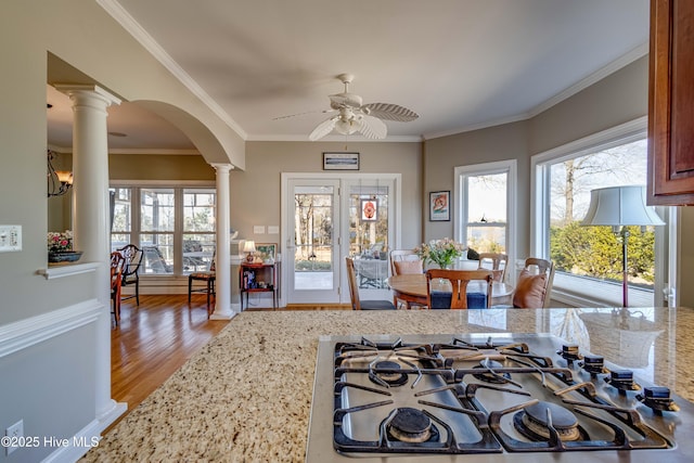 kitchen with light hardwood / wood-style floors, gas stovetop, ornate columns, and light stone counters