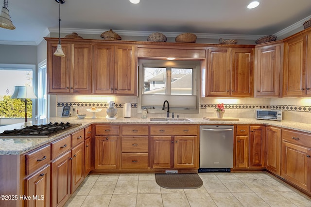 kitchen featuring stainless steel appliances, sink, ornamental molding, light stone counters, and pendant lighting