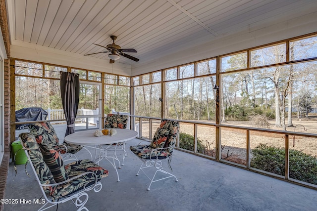 unfurnished sunroom featuring ceiling fan