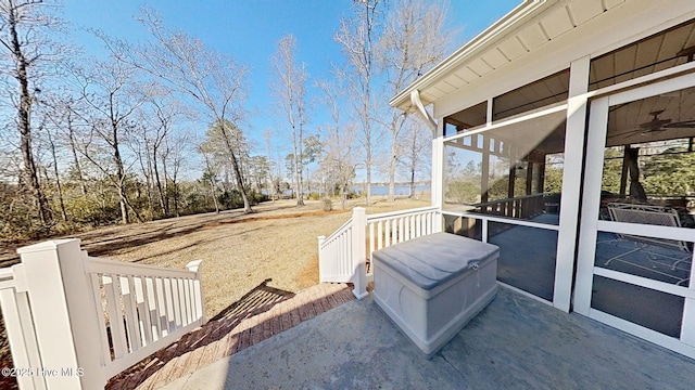 view of patio with ceiling fan and a sunroom