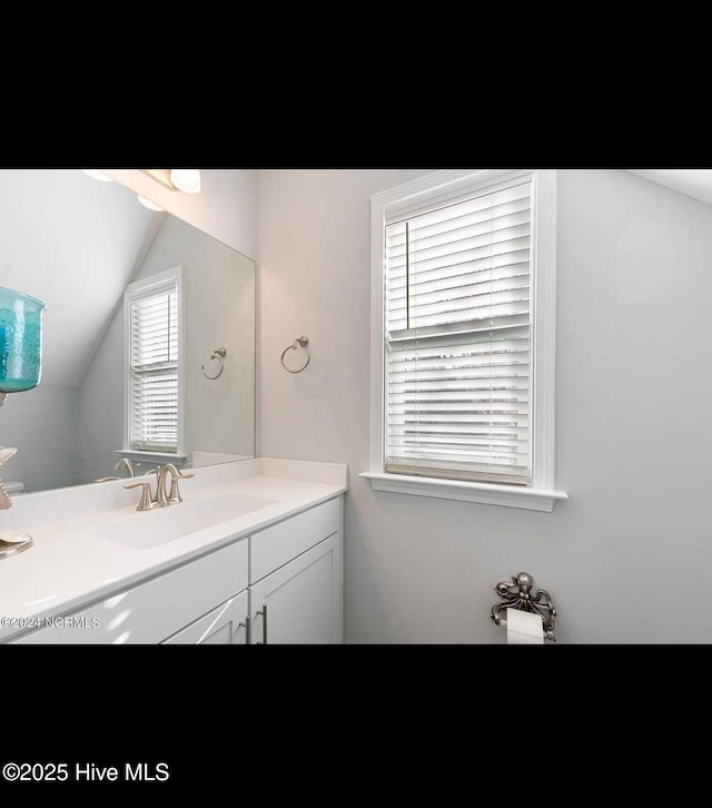 bathroom featuring vanity and lofted ceiling