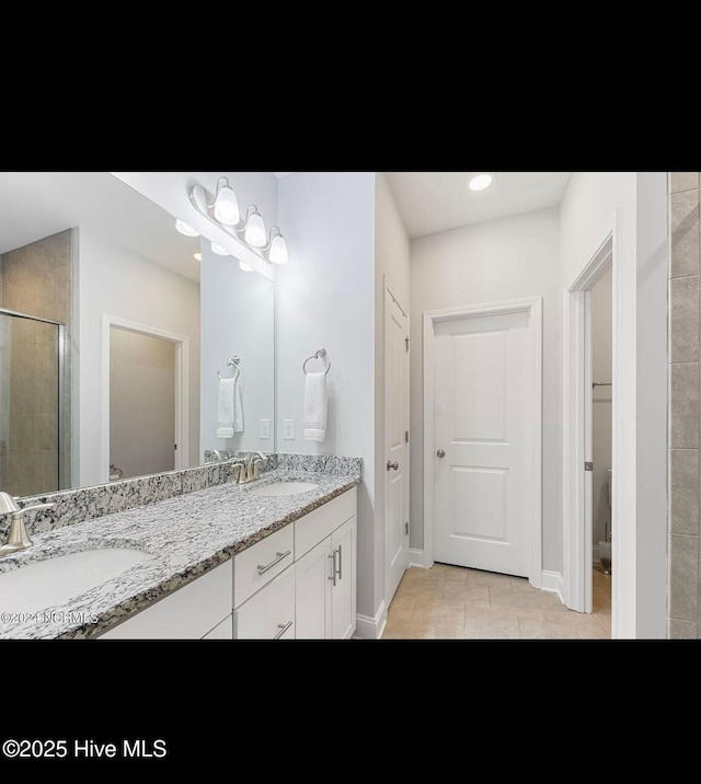 bathroom with vanity, an enclosed shower, and tile patterned flooring