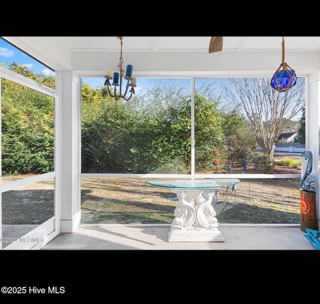 unfurnished sunroom featuring a chandelier