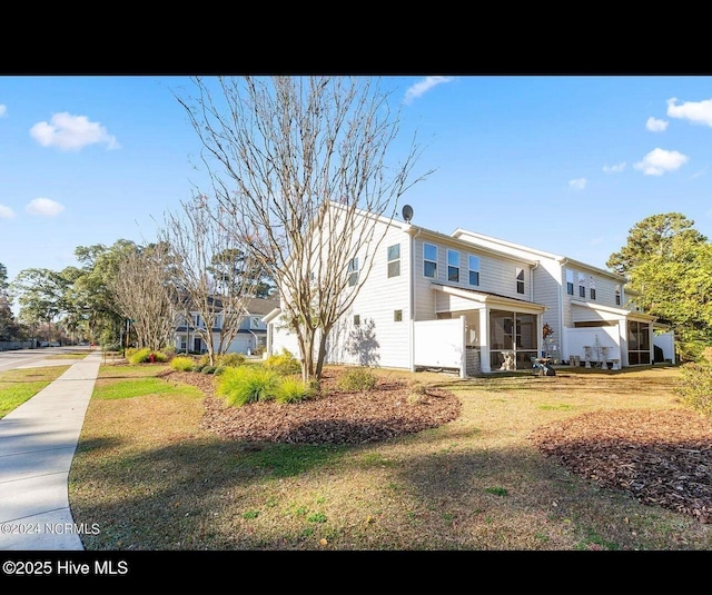 view of side of home featuring a yard and a sunroom