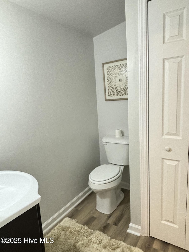 bathroom with vanity, hardwood / wood-style flooring, and toilet