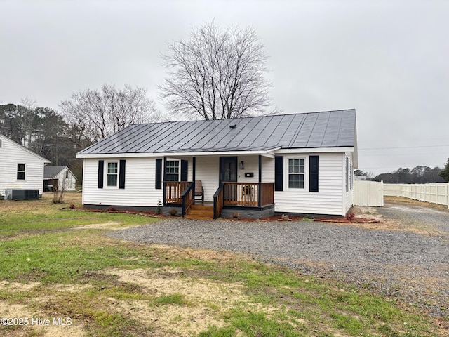 ranch-style house featuring a front lawn, central air condition unit, and covered porch