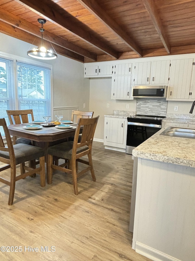 kitchen featuring sink, white cabinets, pendant lighting, electric stove, and exhaust hood