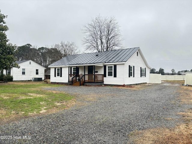 ranch-style house featuring a front yard, covered porch, and central air condition unit